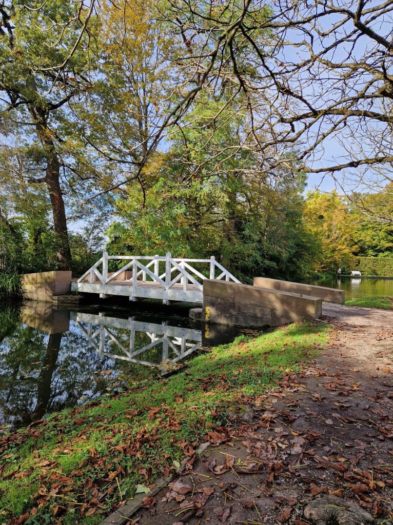 Weisse Brücke über einen kleinen Bach. Eine Brücke verbindet und schliesst eine Kluft zwischen zwei Seiten.
